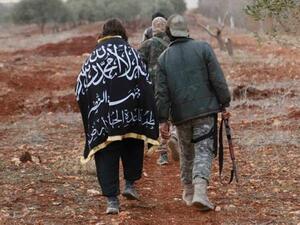 A member of al Qaeda's Nusra Front wears The Nusra flag as he walks with his fellow fighters near al-Zahra village, north of Aleppo city, November 25, 2014. (AFP/File)