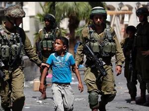 In this file picture, Israeli soldiers arrest a young Palestinian boy following clashes in the occupied West Bank town of al-Khalil (Hebron). (AFP/File)