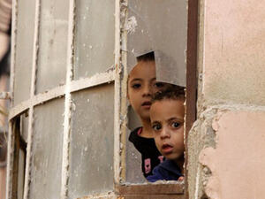 Palestinian children look through a window at Israeli soldiers conducting searches in the Palestinian al-Fawwar refugee camp, south of the West Bank city of Hebron. (AFP/File)