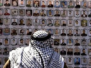 An elderly man looks at pictures of Palestinian prisoners held in Israeli jails during a protest in East Jerusalem on April 15, 2010. (AFP/File)