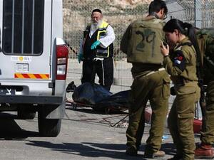 Israeli forces stand next to the body of a Palestinian who was shot dead following an alleged attempt to stab Israeli border police, at a checkpoint near the Israeli settlement of Har Homa in the occupied West Bank, on February 14, 2016. (AFP/File)