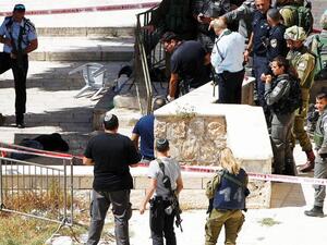 Israeli occupation forces gather around a wounded Palestinian near the Ibrahimi mosque in Hebron on Monday. (AFP/File) 