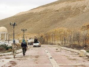 Syrian troops walk down a street in the ancient city of Palmyra on March 24, 2016. (AFP/File)