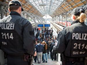 Policemen look at a group of refugees waiting on a platform of the main station in Munich, Germany. (AFP/File)