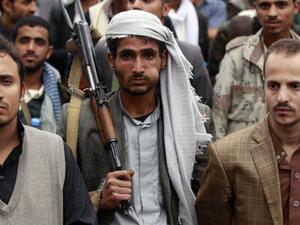 A supporter of the Shia Houthi movement chews Qat, a mild drug used daily by most Yemenis, as he carries a rifle during a demonstration against the Saudi-led air strikes, in the capital Sanaa, on May 8, 2015. (AFP/Mohammed Huwais)