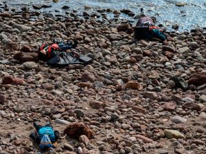 Three bodies are washed up on a beach after authorities said at least 37 people were killed when their boat capsized in the Aegean Sea while trying to cross to Greece from Canakkale province, Turkey, Jan. 30, 2016. (AFP/Ozan Kose)