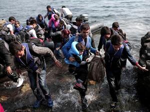 Syrian refugees land on the shores of the Greek island of Lesbos in an inflatable dingy across the Aegean Sea from Turkey, September 3, 2015. (AFP/Angelos Tzortzinis)