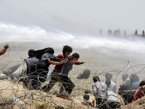 Turkish soldiers use water cannon to move Syrian refugees from border fences at Akcakale in Sanliurfa province, on June 13, 2015. (AFP/Bulent Kilic)