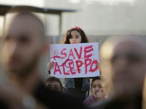 A Syrian girl holds a placard during a rally in solidarity with Aleppo, in the Lebanese northern port city of Tripoli, on May 1, 2016. (AFP/Ibrahim Chalhoub)