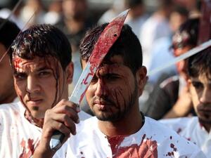Iraqi men take part in a self-flagellation procession on the tenth day of the mourning period of Muharram, which marks the day of Ashura on October 24, 2015, in Baghdad's northern district of Kadhimiya. (AFP/Ahmad al-Rubaye)