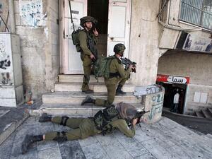 Israeli soldiers aim their guns at Palestinian youths during clashes in Hebron on October 4, 2015.  (AFP/Hazem Bader)