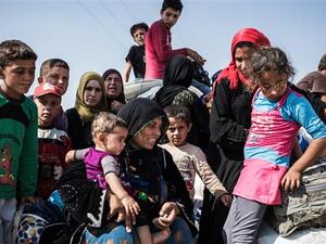 This file photo shows Syrian refugees, who had fled Tal Abyad, re-entering Syria with their belongings from Turkey, June 22, 2015. (AFP/File)