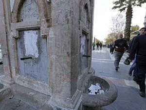 Syrians walk past a water fountain that is running dry as shortages leave over 5 million people with little to no running water. (AFP/File)
