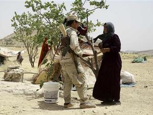 Syrian woman, who fled the assault in Manbij, talks to a Kurdish fighter at an encampment on the outskirts of the town, June 4, 2016. (AFP/File)