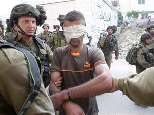 A Palestinian is arrested by Israeli forces on June 21,2014 in the occupied West Bank village of Beit Ola, near the town of Hebron. (AFP/Hazem Bader)