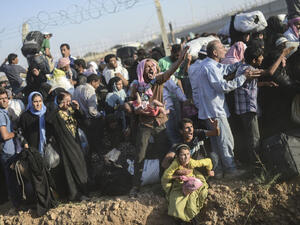 Syrians fleeing the war pass through broken border fences and trenches to enter Turkish territory. (AFP/File)