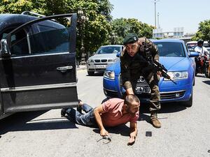 The Turkish policeman restrains a man during an operation in front of a courthouse in Ankara. (Twitter)