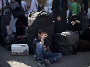 A Palestinian boy waits with his family to cross into Egypt at the Rafah crossing between Egypt and the southern Gaza Strip. (AFP/Mahmud Hams)