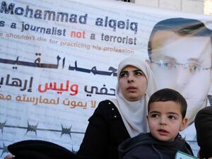Fayha Shalash, the wife of Mohammed al-Qiq, with her son Islam. (AFP/Abbas Momani)