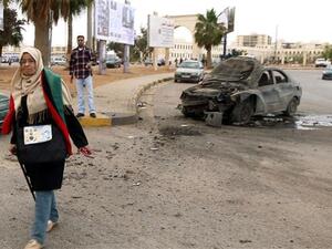 A woman walks near a damaged car after shelling hit a protest rally in Benghazi on May 6, 2016. (AFP/File)