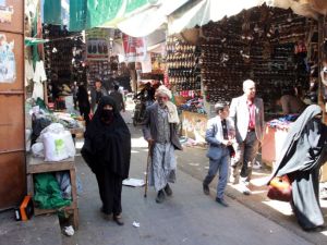 Yemenis walk past stalls at a market on November 19, 2016 in the capital Sanaa. (AFP/File)