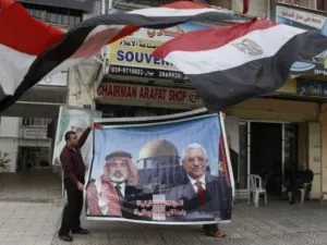 فلسطيني يعرض صورة كبيرة لرئيس الحكومة المقالة اسماعيل هنية ورئيس السلطة الفلسطينية محمود عباس بعد اعلان التوصل الى اتفاق مصالحة