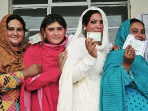 Pakistani voters pose with their national identity cards as they queue to cast their ballots at a polling station during the general election in Rawalpindi. (AFP/ File)