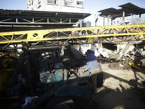 A Palestinian man surveys a damaged vehicle after an Israeli airstrike on Gaza on May 5, 2016. (AFP/Mohammed Abed)