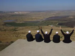 Druze men at the Israeli-annexed Golan Heights flash the V for victory sign as they look out across the southwestern Syrian province of Quneitra on July 7, 2018. (Jalaa Marey/AFP/Getty Images) 