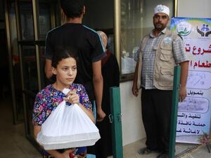 A Palestinian girl receives food from the tekiyya, Arabic name for the soup kitchen, during the holy Muslim month of Ramadan in Gaza City on June 13, 2016. (AFP/Mohammed Abed)