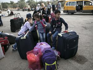 Palestinian children wait as they wait to cross with their families into Egypt through the Rafah border crossing on October 16, 2016 in the southern Gaza Strip. (AFP/Said Khatib)