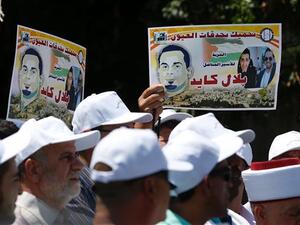 Palestinian protesters hold posters against the administrative detention of Palestinian prisoner Bilal Kayed outside the International Committee of the Red Cross’s offices in East Jerusalem on August 12, 2016. (AFP/File)