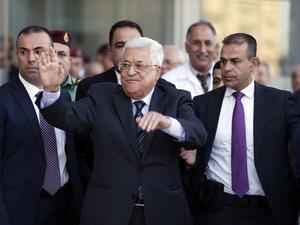 Palestinian president Mahmud Abbas (C) waves as he is escorted out of the Istishari Hospital in the West Bank city of Ramallah on October 6, 2016, following his discharge. (AFP/Abbas Momani)