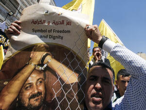 A Palestinian protester holds a picture of Marwan Barghouti during a rally to support the prisoners' strike in the West Bank town of Hebron, April 17 2017. (AFP/Hazem Bader)