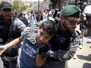 Israeli border guards detain a protester during a demonstration outside the Lions Gate in Jerusalem's Old City on July 17, 2017. (AFP/ Ahmad Gharabli)