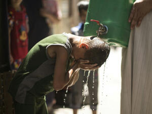 Israel is to supply millions of cubic metres of water to Palestinians including in the Gaza Strip, where a Palestinian boy is seen here cooling off with water from a jerrycan during a heatwave on July 2, 2017. (AFP)