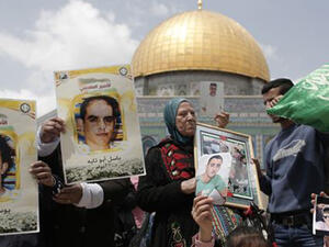 Palestinian protesters hold portraits of prisoners during a rally marking the Palestinian Prisoner Day at the al-Aqsa Mosque compound in Jerusalem. (AFP)