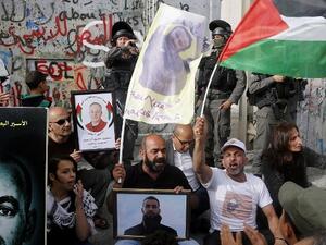Palestinians protest in solidarity with security prisoners on a hunger strike by the security barrier in the West Bank city of Bethlehem on April 26, 2017. (AFP/Musa Al Shaer)