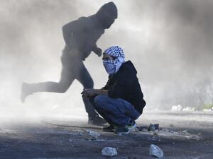 Palestinian protesters clash with Israeli troops near an Israeli checkpoint in the West Bank city of Ramallah on December 8, 2017 (Abbas Momani/AFP)
