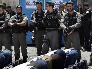Israeli forces stand guard as Palestinian Muslim worshippers, who refuse to enter Al-Aqsa mosque compound due to newly-implemented security measures by Israeli authorities. (AFP)