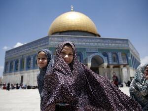 Palestinian girls stand in front the Dome of the Rock as they attend the first Friday prayers of the Muslim holy month of Ramadan at Jerusalem's al-Aqsa mosque compound on June 2, 2017. (AFP/Ahmad Gharabli)