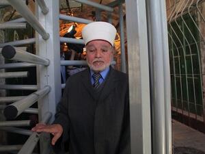 The Mufti of Jerusalem and Palestine, Sheikh Mohammed Hussein, passes through an iron gate as he crosses an Israeli checkpoint in the occupied West Bank city of Hebron. (AFP/ Hazem Bader) 