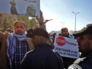 Palestinian protesters hold placards during a demonstration east of Jerusalem against US President-elect Donald Trump. (AFP/File)