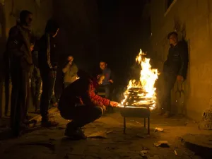 Palestinians gather around a fire during a power cut in the Al-Shati refugee camp in Gaza City, on January 4, 2017. (AFP/Mahmud Hams)