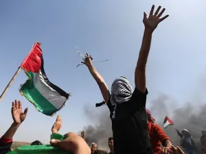 Palestinian demonstrators wave their national flag and shout slogans against Israeli army during protest on the Israel-Gaza border in Gaza Strip. (AFP/Mohammed Abed)
