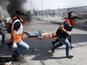 Palestinian medics carry away a protester who was injured during clashes with Israeli security forces in the West Bank city of Qalandiya, north of Jerusalem. (Abbas Momani/ AFP)
