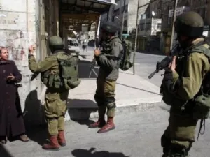 Israeli soldiers stop a Palestinian woman in the Palestinian side of the city of Hebron. (AFP/ File)