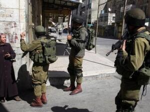 Israeli soldiers stop a Palestinian woman in the Palestinian side of the city of Hebron. (AFP/ File)