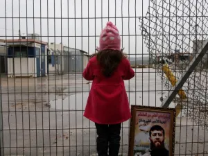 Maali, daughter of jailed Islamic Jihad spokesman Khader Adnan, stands next to a picture of her father outside a prison. (AFP/Abbas Momani)