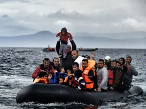 A man holds up a young boy as a boat carrying migrants and refugees arrives at the Greek island of Lesbos after crossing the Aegean sea from Turkey on October 21, 2015 (AFP/ File Photo)